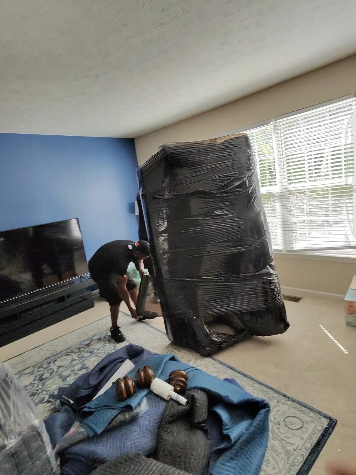 ASAP Moving crew member working beside wrapped furniture and moving blankets in Avon Lake, Ohio.