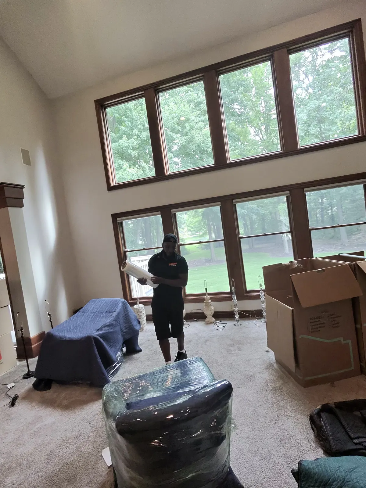 ASAP Moving crew member in a room with wrapped furniture and packed boxes in Avon, Ohio.